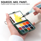 Water brush mixing yellow paint in the lid of a green portable watercolor palette