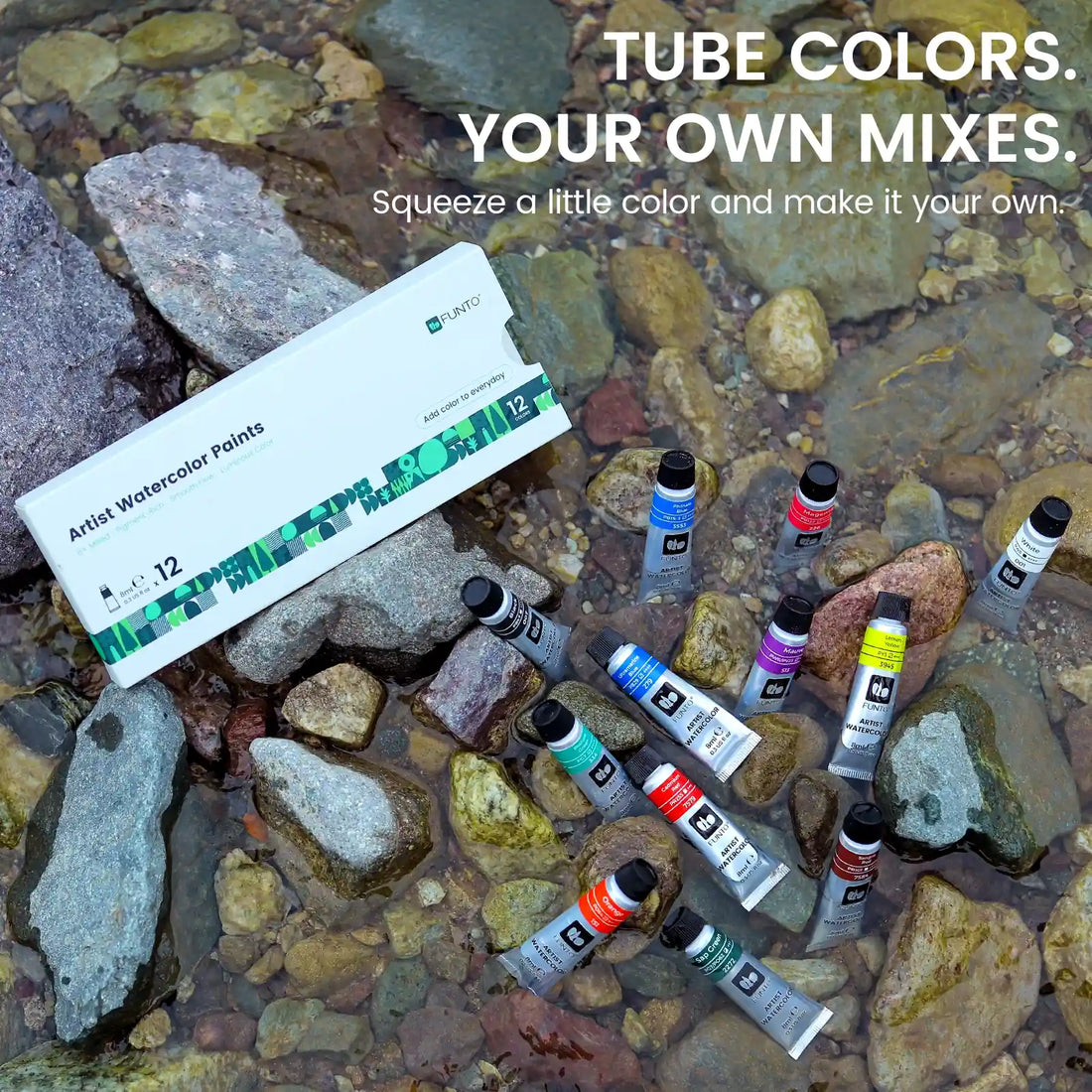 FUNTO watercolor paint tubes and their box arranged on rocks beside flowing water